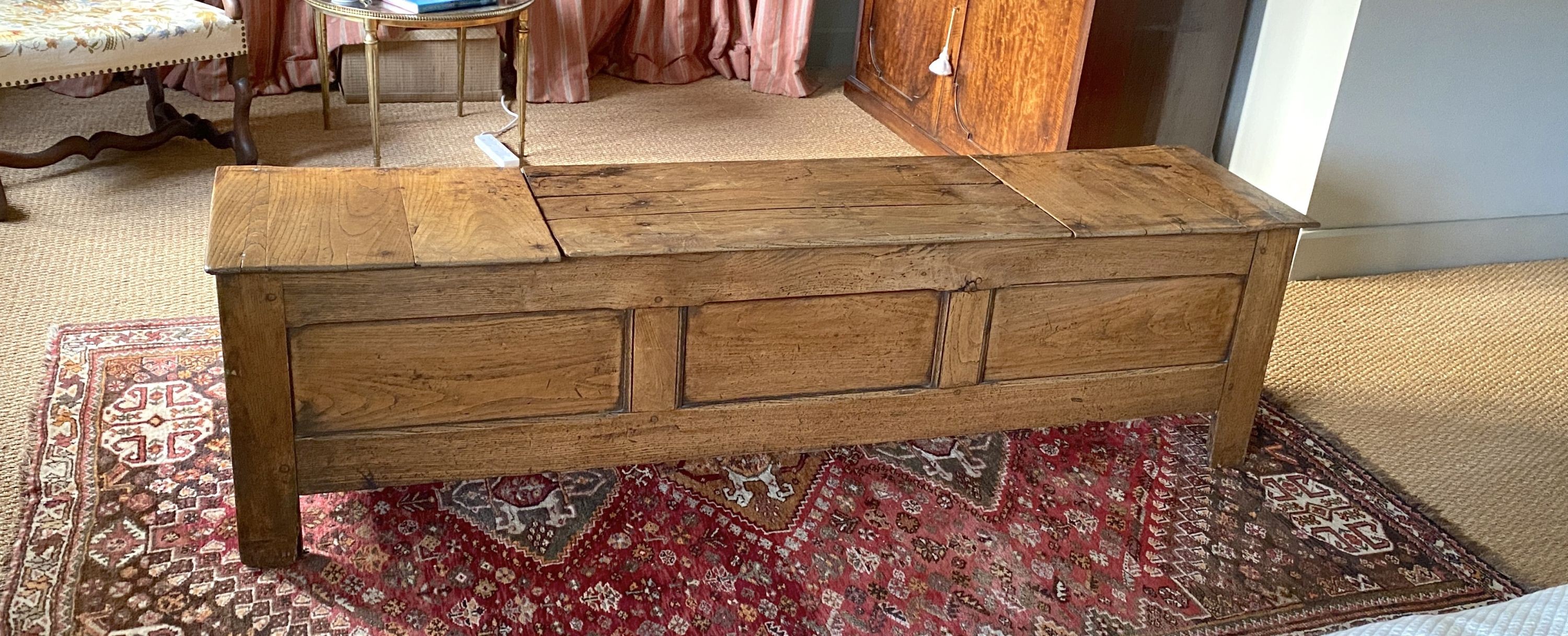 A 17th century style elm blanket box, with central rising lid and panelled front, width 180cm depth 44cm height 51cm